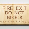 Eco-friendly ADA braille wood sign using 3D printing that says “Fire Exit Do Not Block"